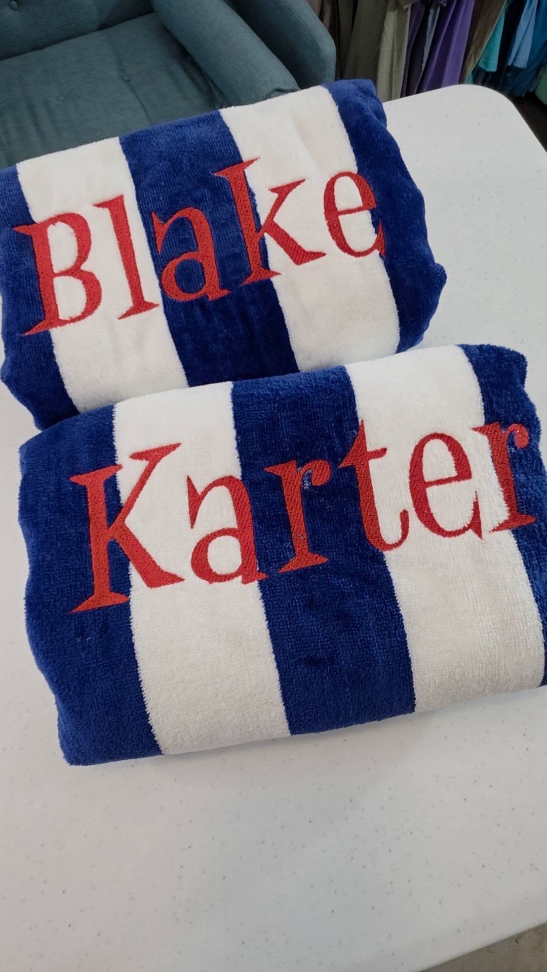 Stack of personalized beach towels with different names for kids and group trips